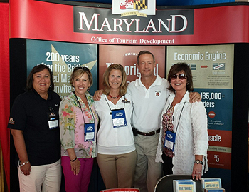 The team from the Maryland Office of Tourism was joined by Gov. Martin O’Malley at the Maryland Association of Counties annual summer conference in Ocean City.  Pictured from left to right:  Margie Long, supervisor, I-95 and I-70 Welcome Center; Hannah L. Byron, assistant secretary, Division of Tourism, Film and the Arts; Marci Ross, assistant director, Maryland Office of Tourism; Gov. O’Malley; and Margot Amelia, executive director, Maryland Office of Tourism.