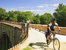 2 bicyclist riding over a bridge.
