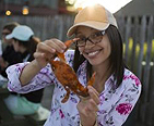 Young lady holding up a steamed crab.