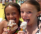 Two girls eating a ice cream cone