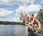 Girls jumping off a pier into the water